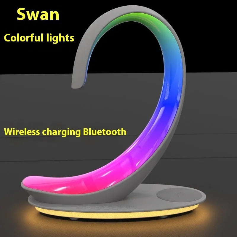 White swan-shaped desk lamp with colourful LED lights, Bluetooth speaker, and wireless charging pad.