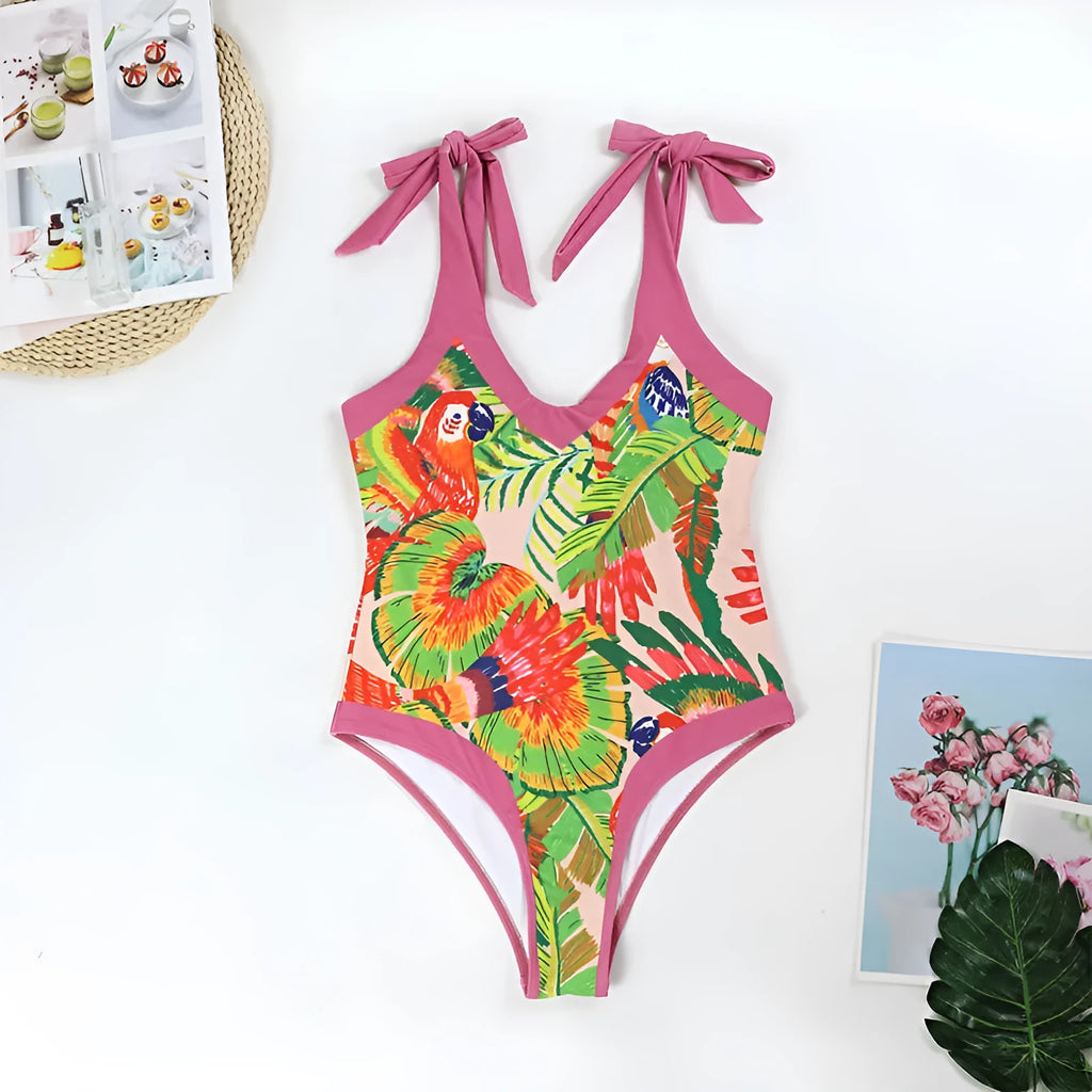 Pink floral print women's one-piece swimsuit with V-neck and matching skirt on beach