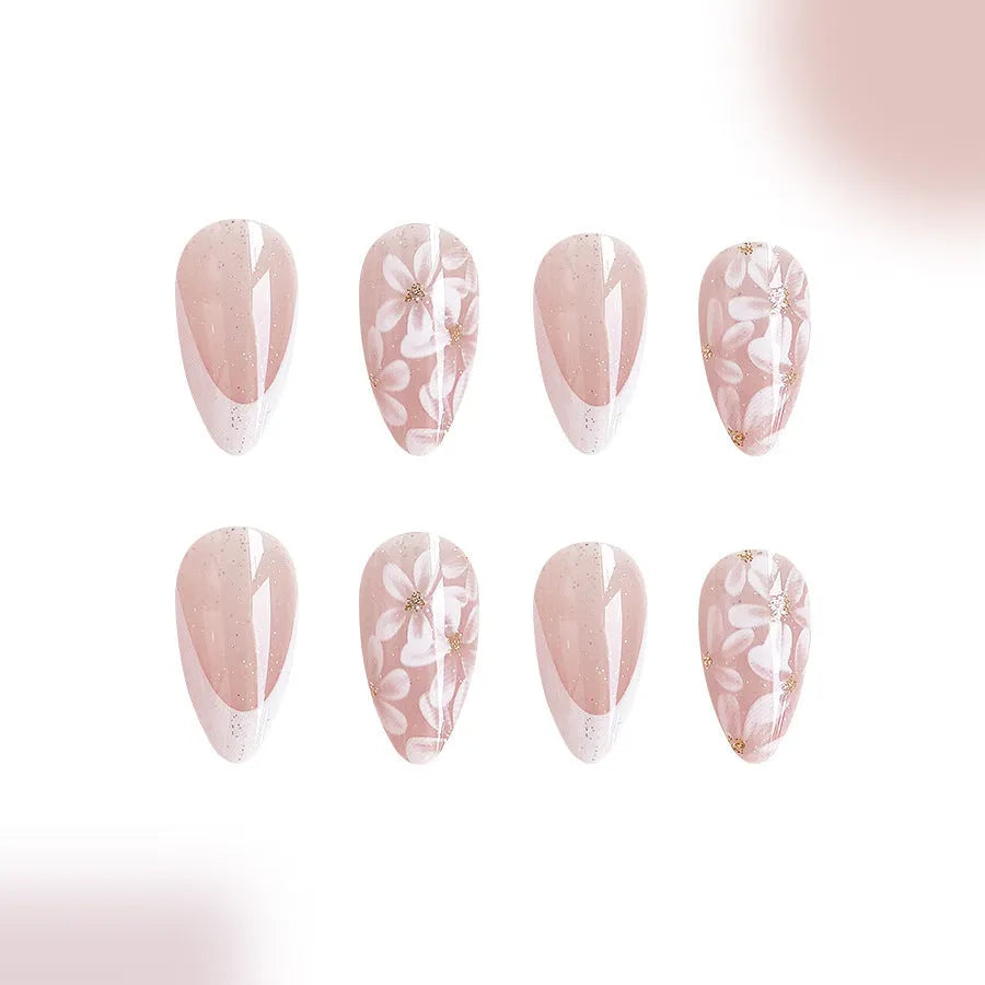 Short almond-shaped press-on nails with French manicure, flower patterns, and glitter accents in colour C625