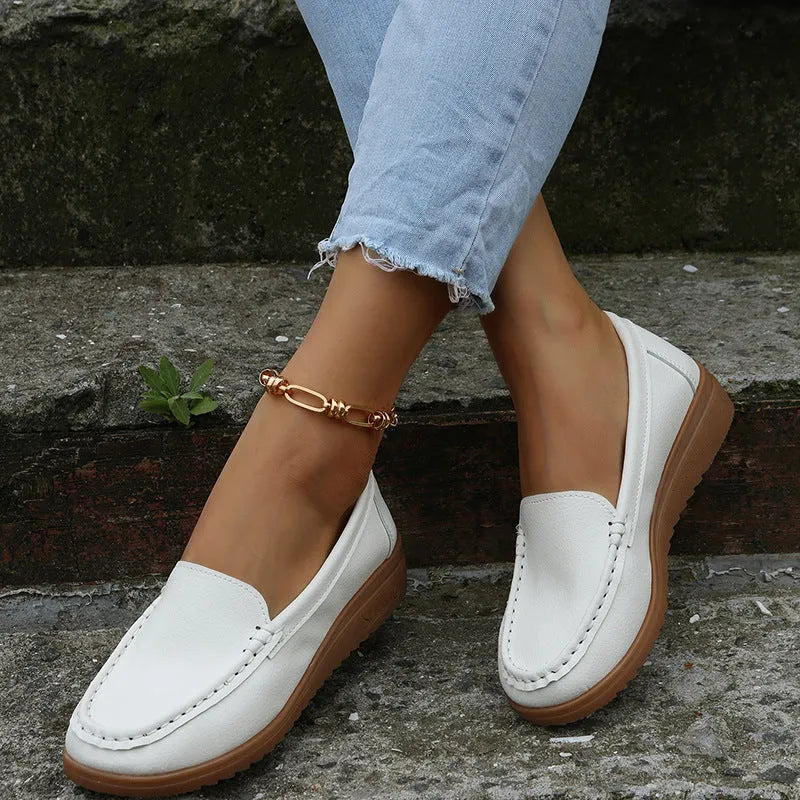 Women's black PU leather flat shoes with round toe and visible car suture stitching detail.