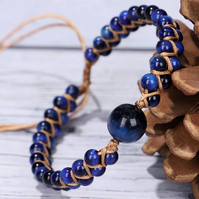 Handmade woven pull bracelet in blue Tigereye or amethyst with geometric design on wrist.