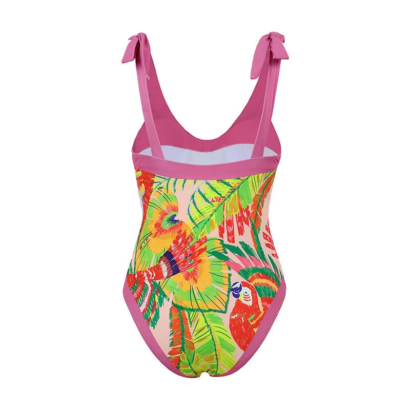 Pink floral print women's one-piece swimsuit with V-neck and matching skirt on beach