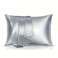 A pair of solid colour satin cloth pillowcases in a chosen shade and size on a bed.