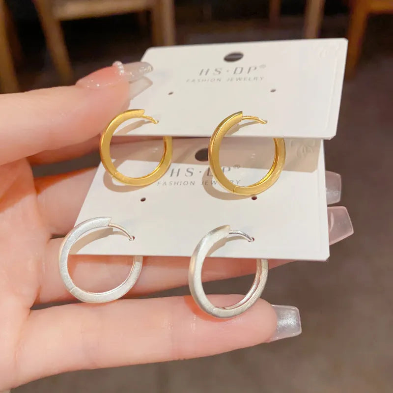Women's geometric ear clip with round design in gold and silver plated finishes
