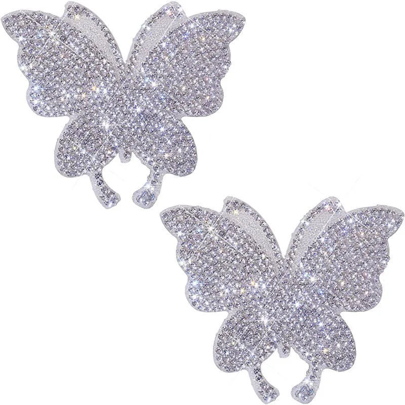 Close-up of a diamond-sparkle glass car sticker in a butterfly or bear paw design on a car surface.