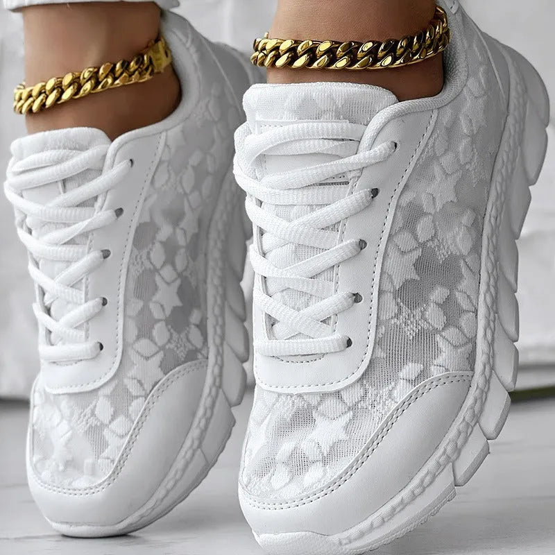Women's white canvas casual running shoes with flat heel and round toe on a plain background.