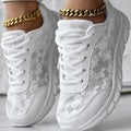 Women's white canvas casual running shoes with flat heel and round toe on a plain background.