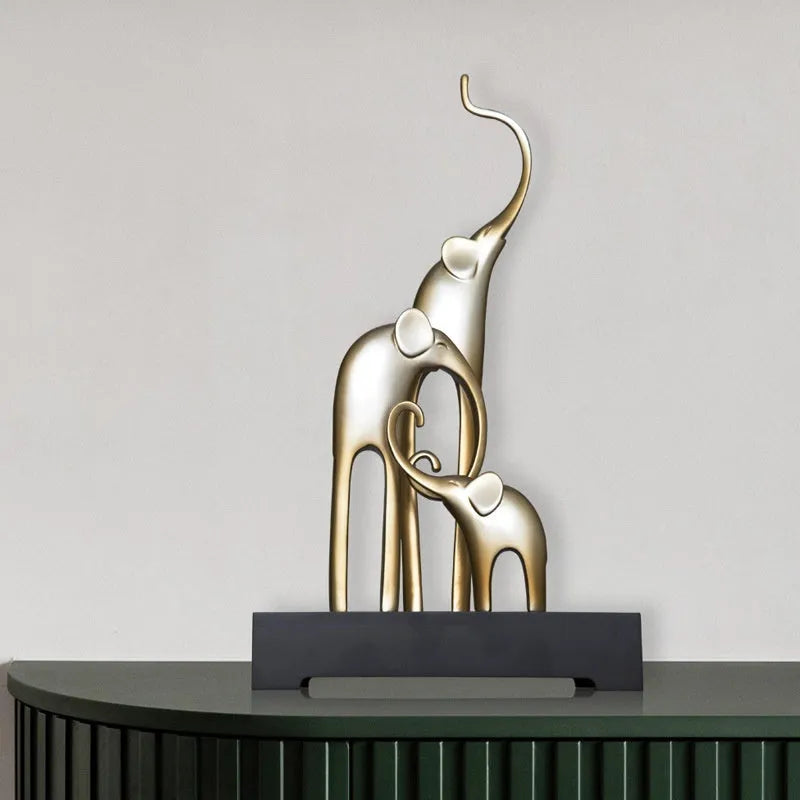 Detailed resin elephant figurine ornament in metallic gold finish on a wooden shelf.