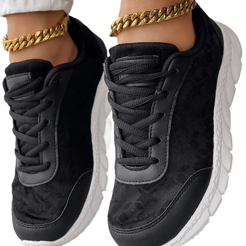 Women's white canvas casual running shoes with flat heel and round toe on a plain background.