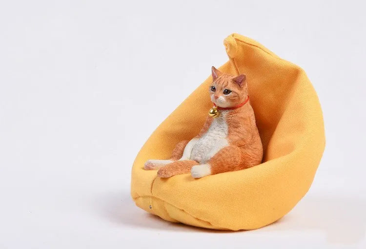 Small lazy cat car ornament and sofa, 7.5cm tall resin model on a car dashboard.