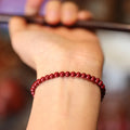 Close-up of a purple gold sand cinnabar bracelet with geometric shapes and auspicious patterns.