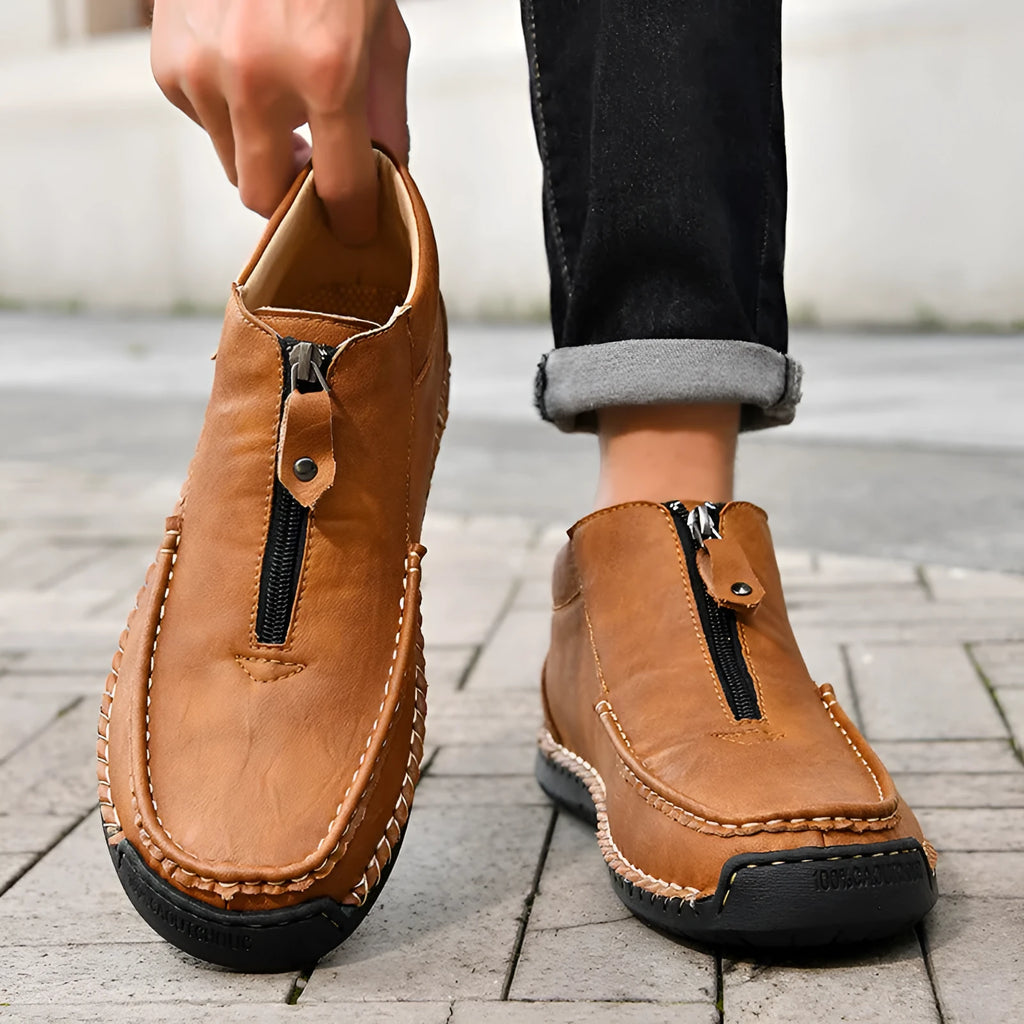 Men's black slip-on casual loafers with a round toe and rubber sole, shown from the side.