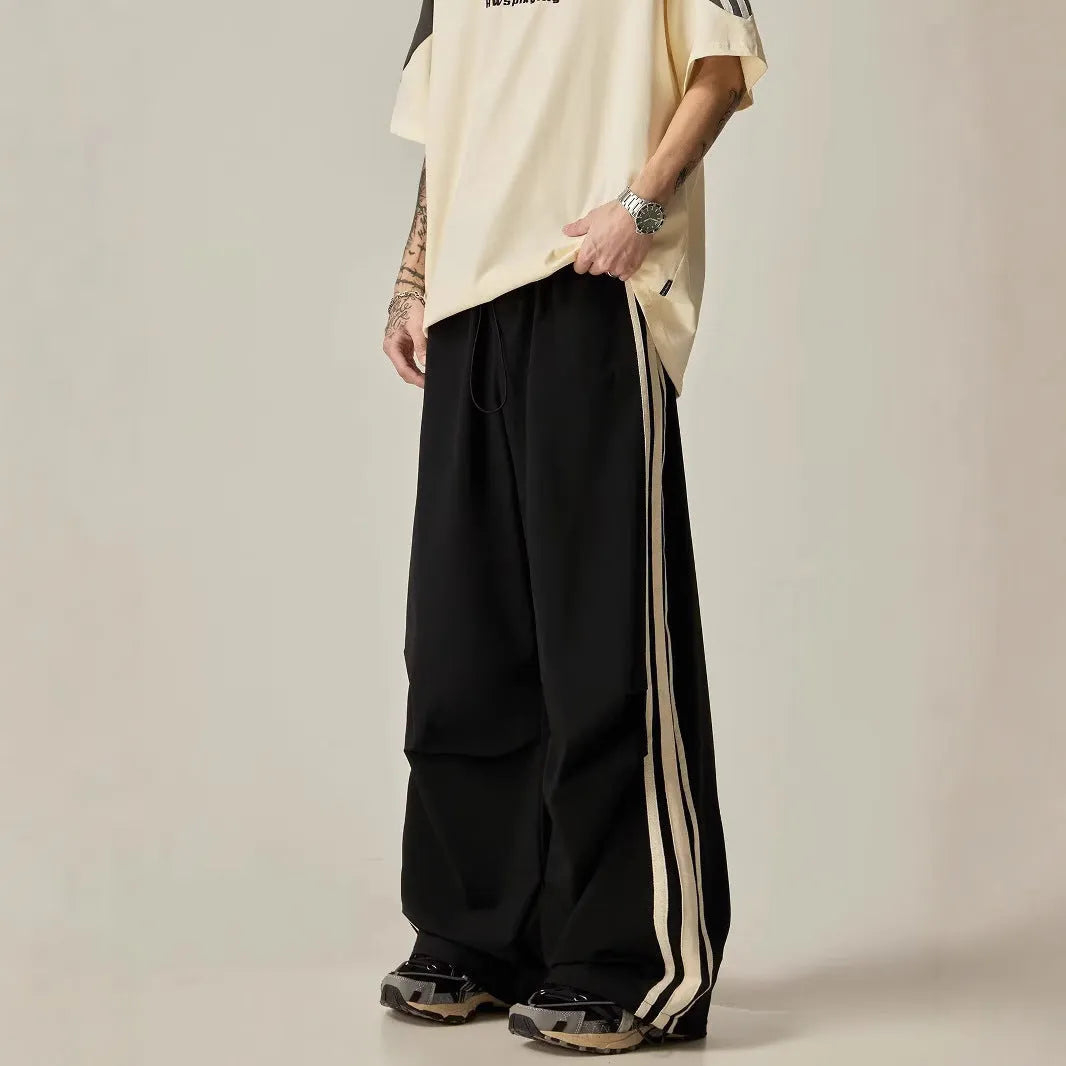 Black high-waisted wide-leg polyester climbing trousers for men laid flat.