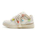 Creamy white retro low-top skate shoes with lace-up front and decorative stitching on a rubber sole.