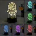 Dream catcher shaped acrylic night light with black base and colourful lighting on wooden surface