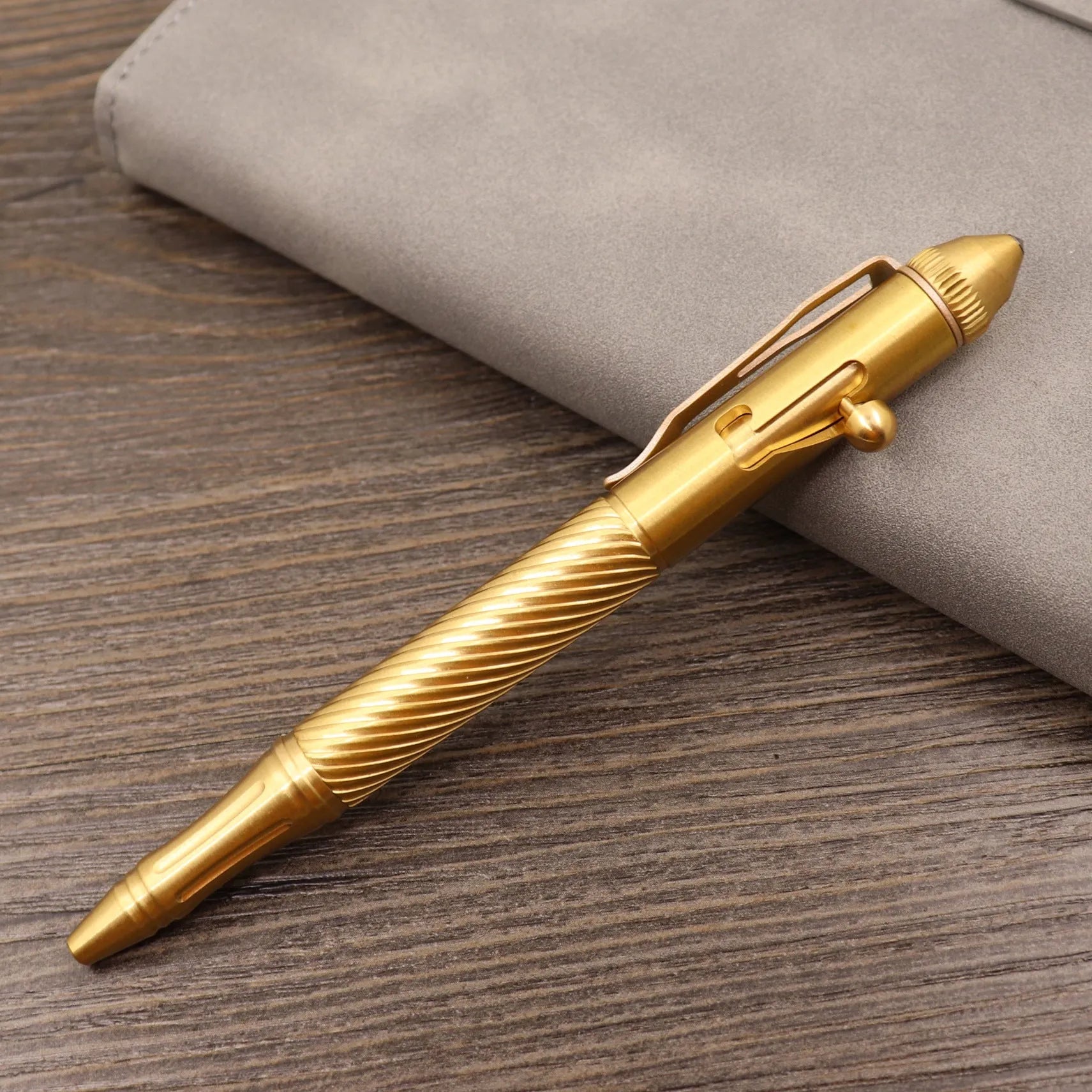 Retro brass tactical pen with cylindrical barrel and six-ring grip, shown with press mechanism extended