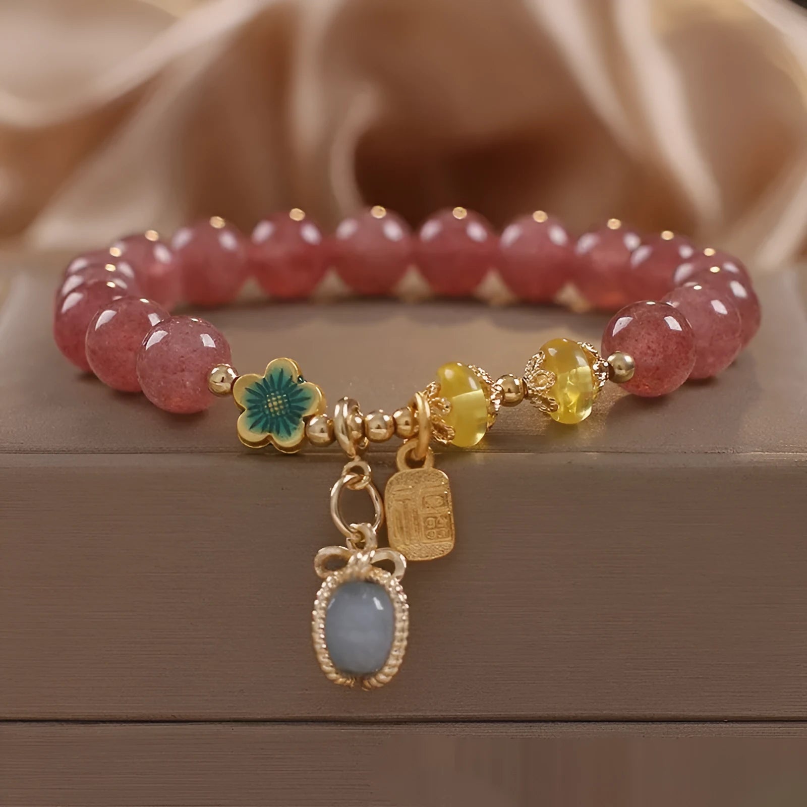 Red strawberry quartz beaded bracelet with alloy metal and rhinestone details
