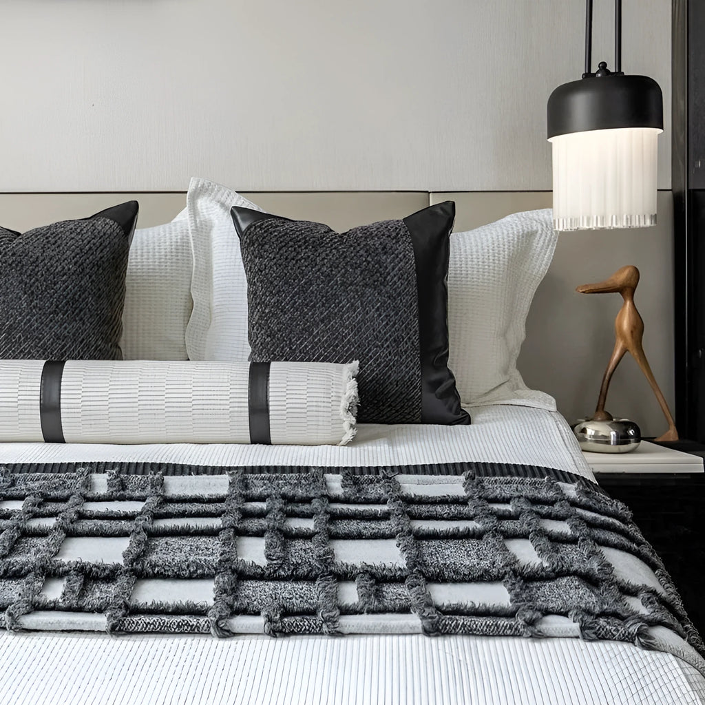 Modern minimalist plaid bed runner set with blanket, pillowcase, and round leather pillow on a bed