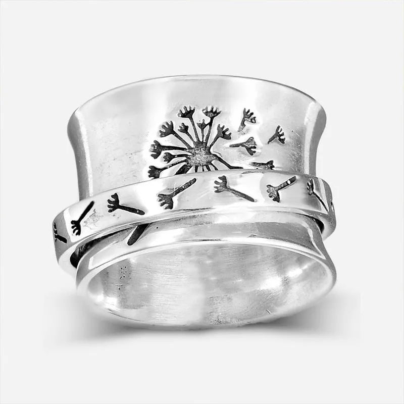 Silver coloured alloy flower ring with rotatable floral detail on a finger.