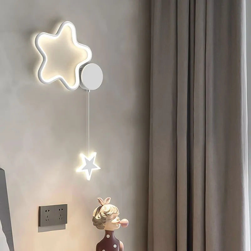 Five-pointed star shaped bedside wall lamp with cloud motif in black finish mounted beside bed