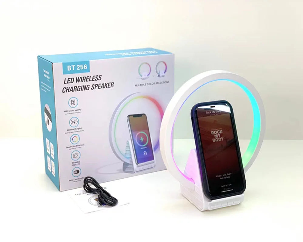 White smart Bluetooth speaker with wireless charging pad, ambience light, and card slot on a desk