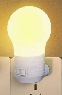 Plug-in bedside baby night light in white shell with modern round design on a table.