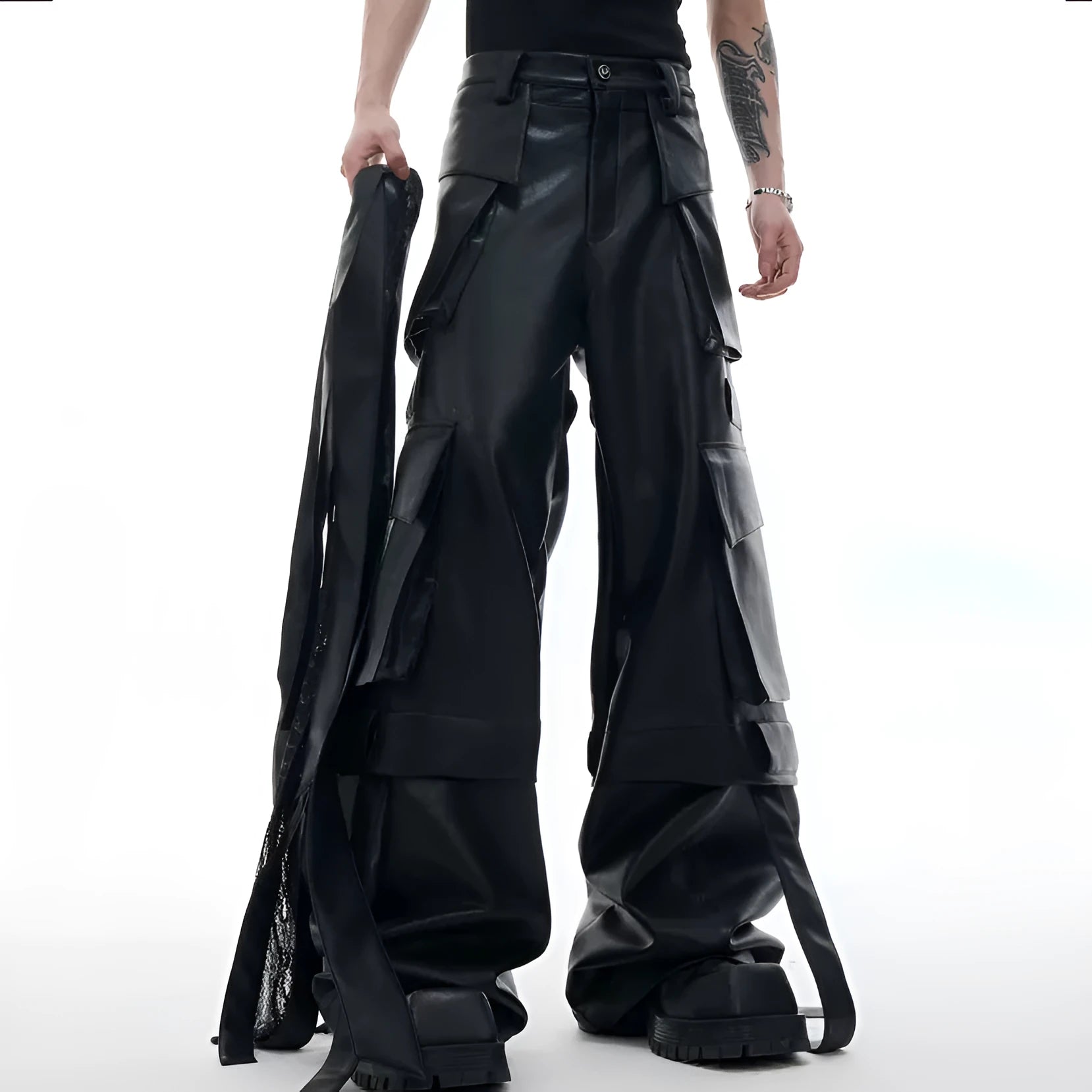 Black loose-fit men's trousers with multiple pockets, quilted panels, and decorative leather ribbon trim.