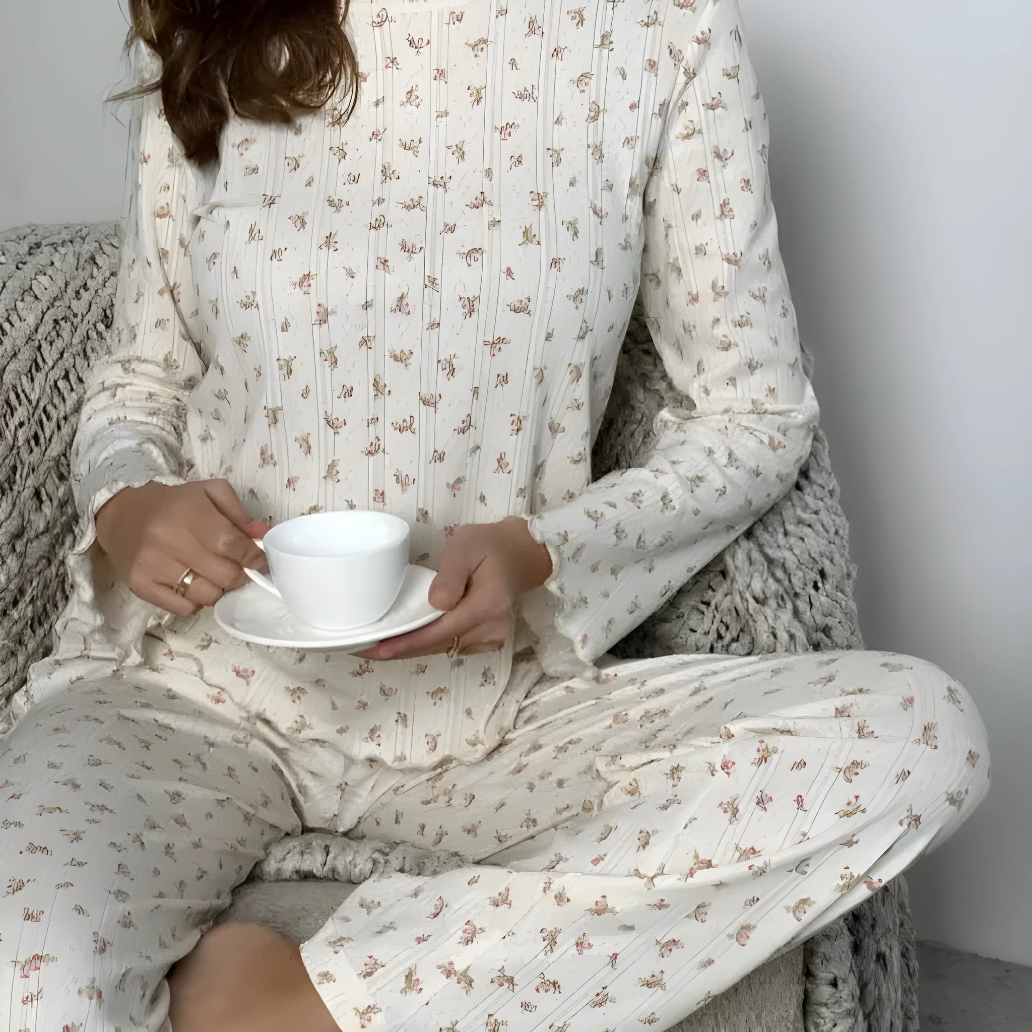 Women's white floral print suit set featuring a round neck top with bell sleeves and wide leg trousers.