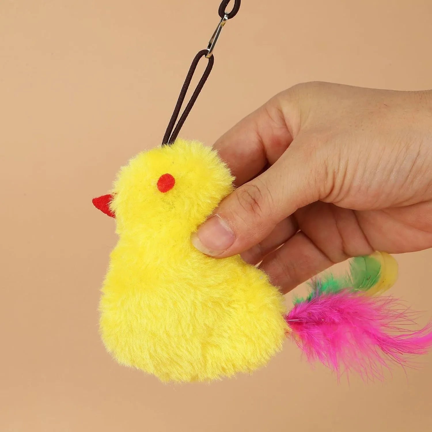 Grey and yellow retractable cat teaser toy hanging on door frame with treat bulb and dangling mouse.