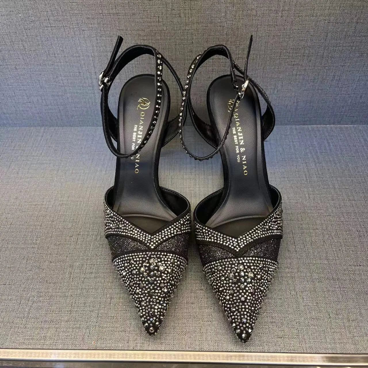 Women's black stiletto high heels with red sole and pointed toe design