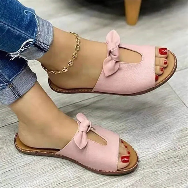 Ladies casual sandals with fish mouth front and decorative bow in black, pink, and gold colours.