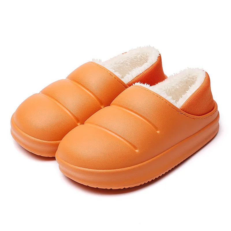 Green waterproof EVA garden slippers with plush lining and a non-slip sole, shown on a wooden deck.