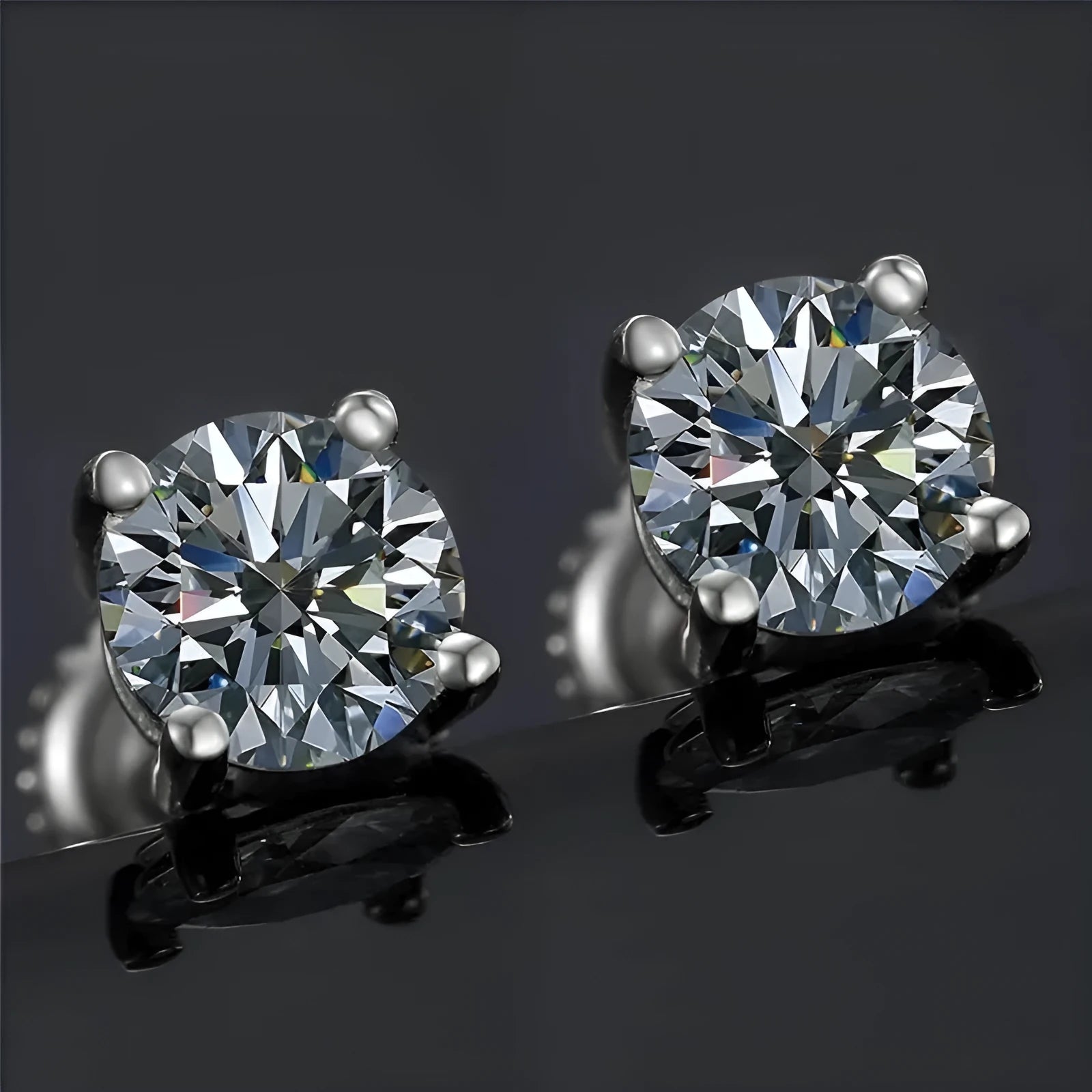 Silver four-claw set moissanite stud earrings with geometric shape and screw-back fittings.