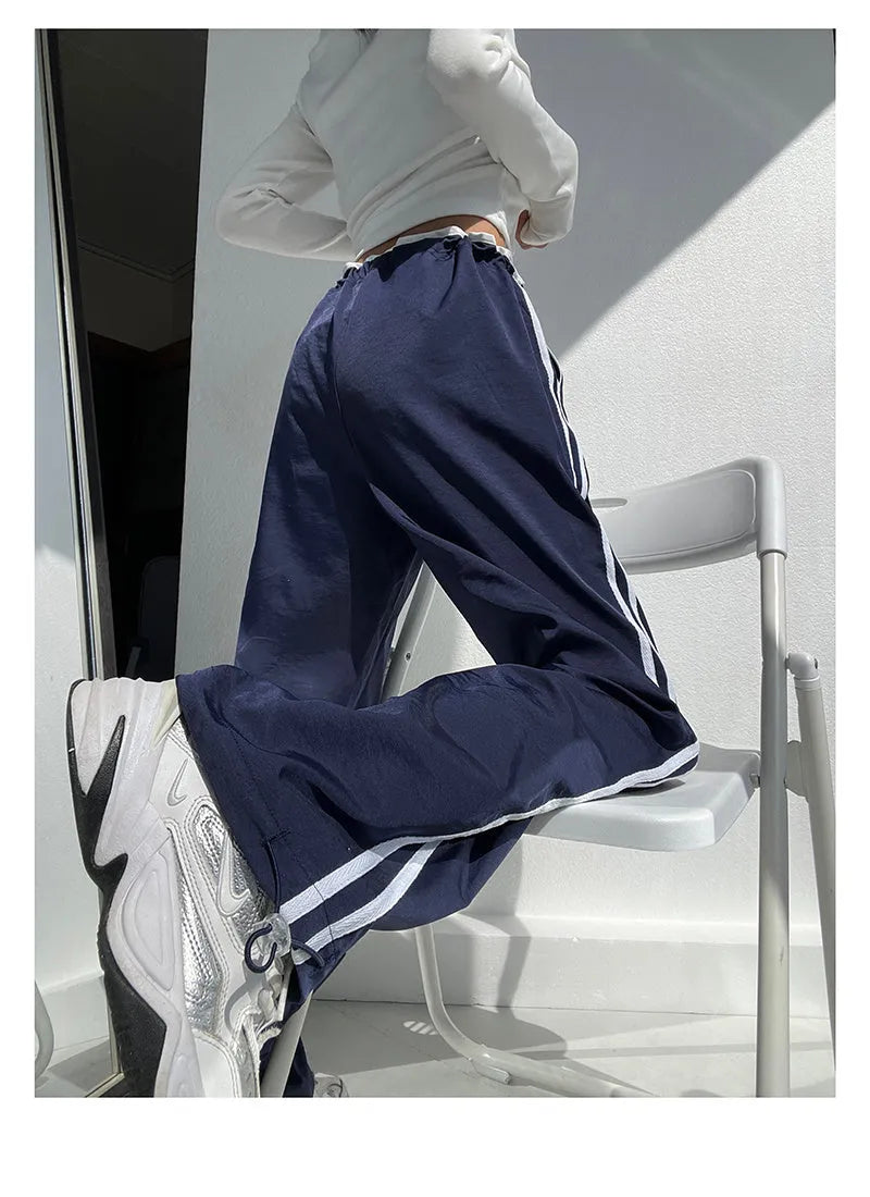Navy blue loose straight-leg trousers with contrast ribbon trim and a slimming drape