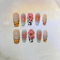 Close-up of hand-carved acrylic press-on nails with a Lily zebra pattern, floral, and leopard print design.