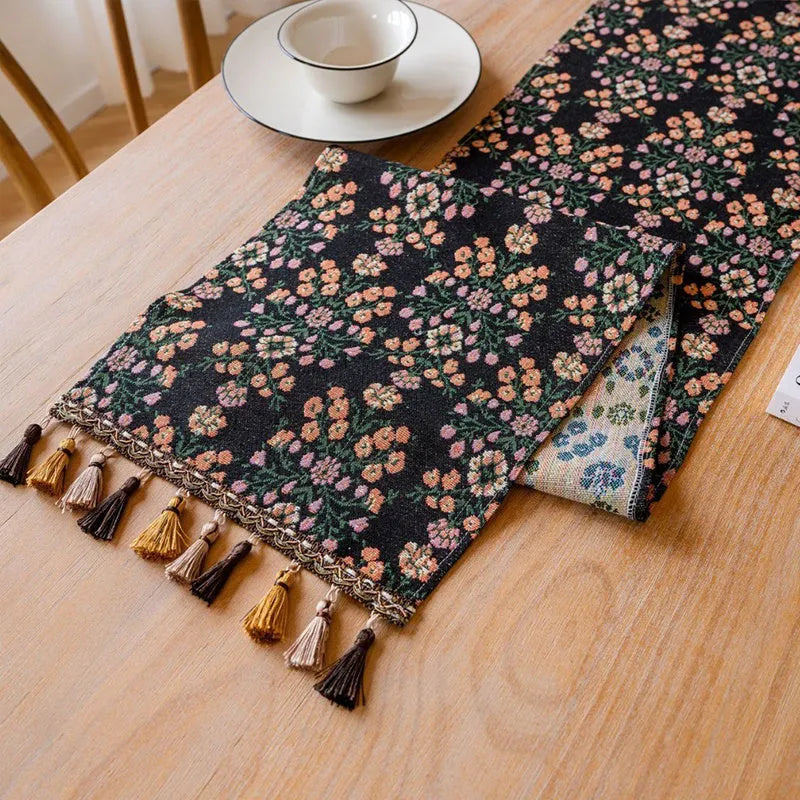 Dark blue Nordic jacquard table runner with bouquet pattern and tassel fringe on wooden table