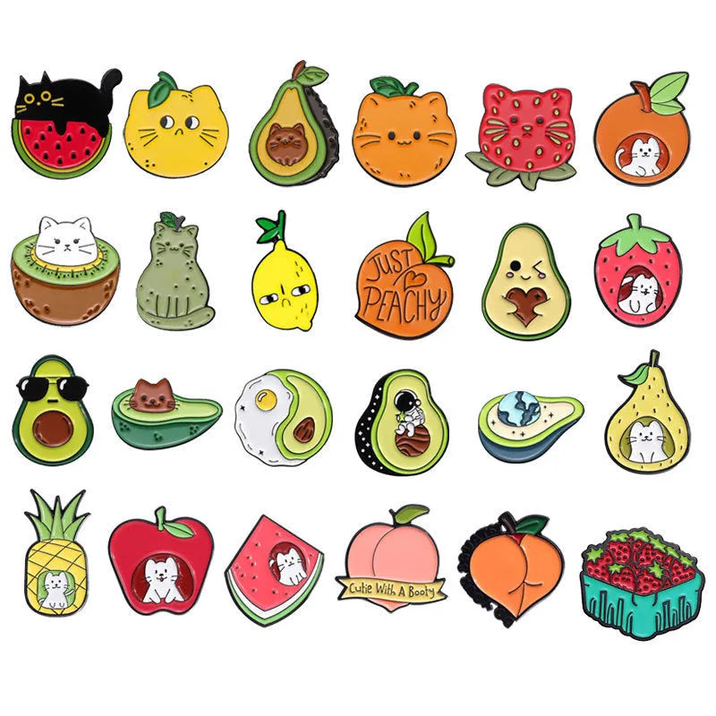 Colourful metal brooch with cartoon fruit and letter design on a blue background.