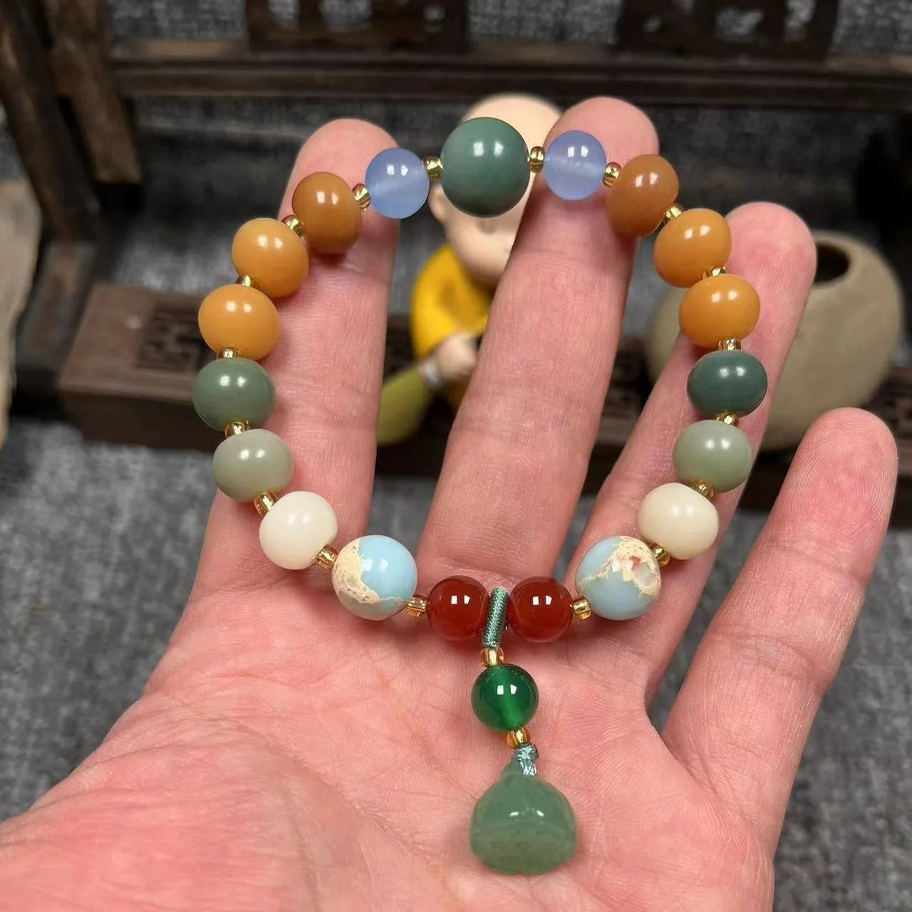 Carved pumpkin and lotus bead bracelet made from Bodhi root with white jade and aventurine details.