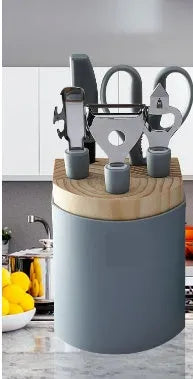 Stainless steel kitchen gadget set with whisk, grater, peeler, fruit knife, scissors, and tray lifter in grey