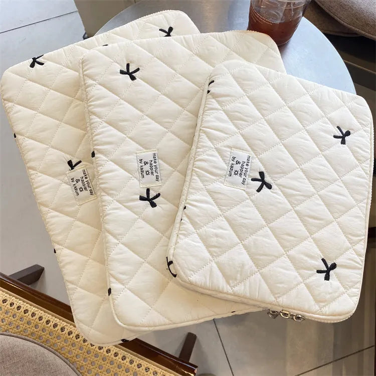 Nylon laptop storage bag with an embroidered rhombus bow in light pink colour.