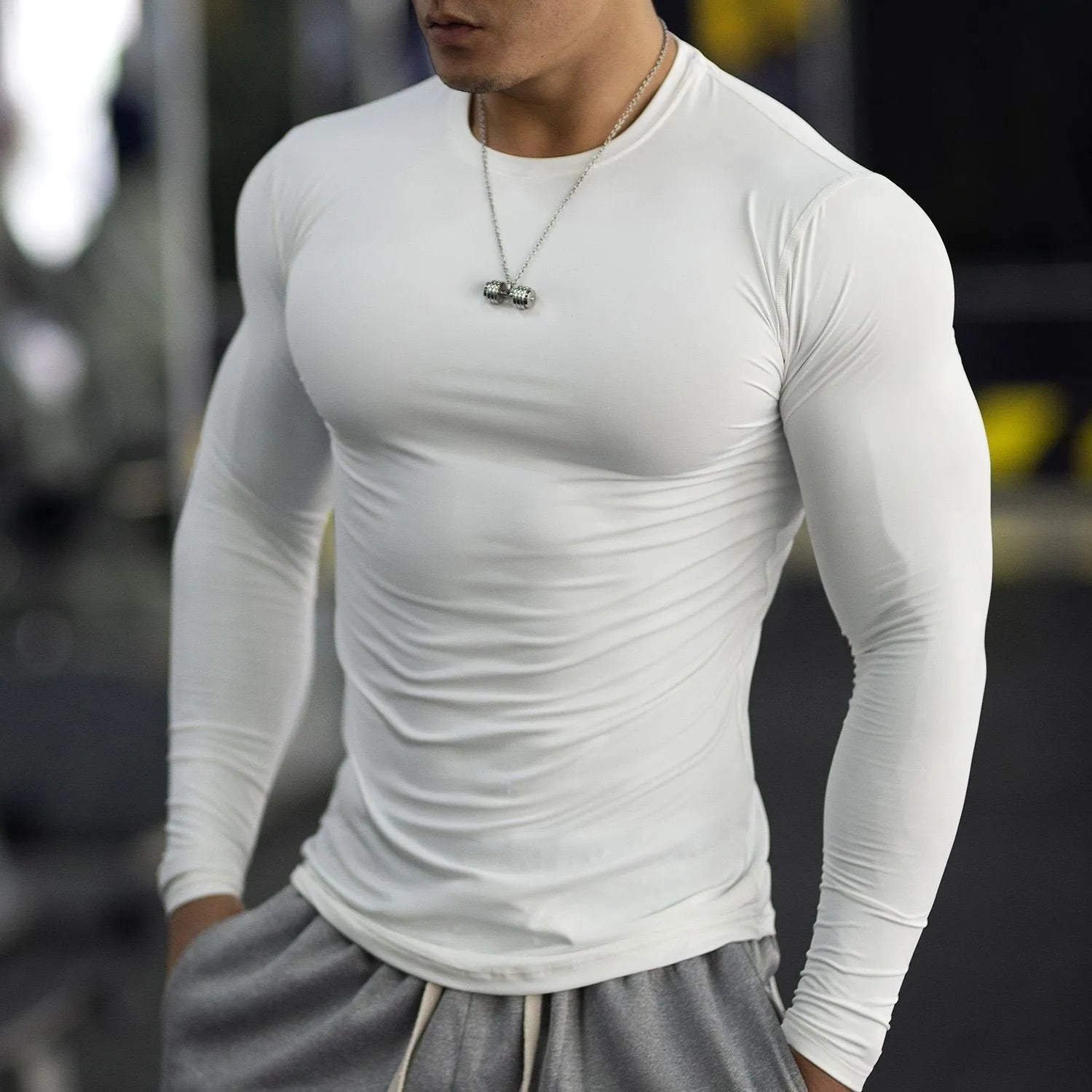 Men's slim fit black fitness tights with long sleeves for running and gym workouts.