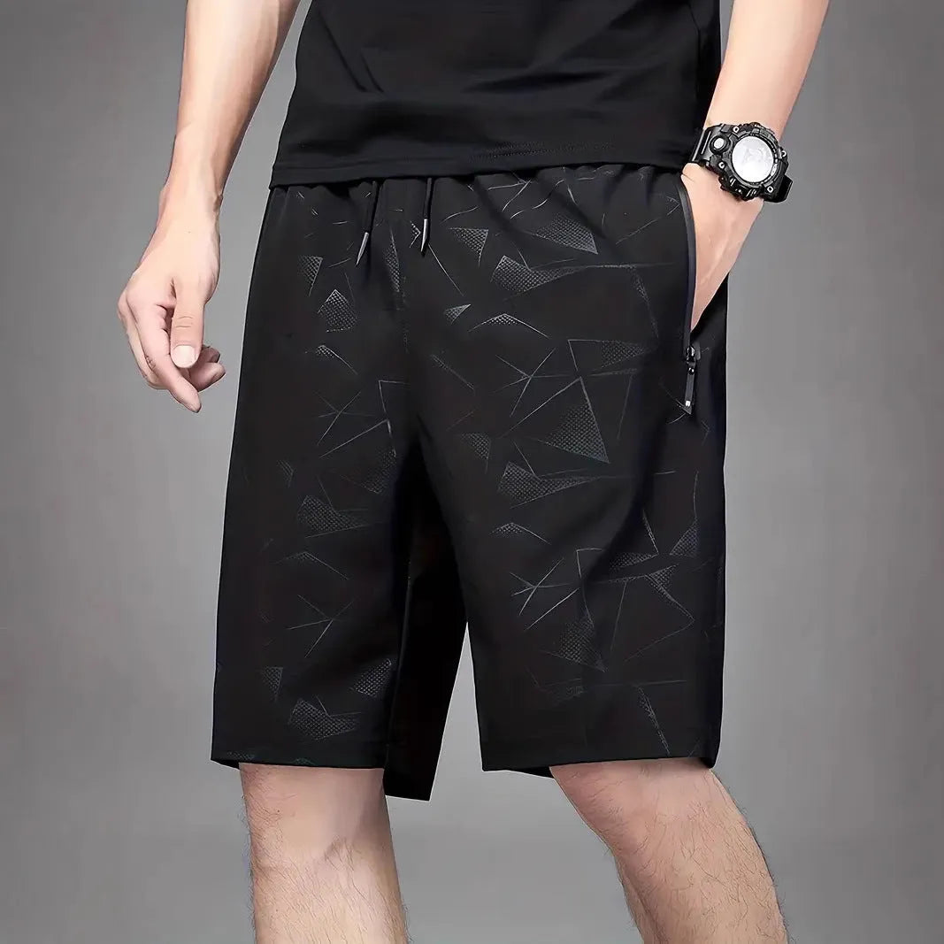 Man wearing loose-fit black printed polyester sports shorts for casual athletic wear.