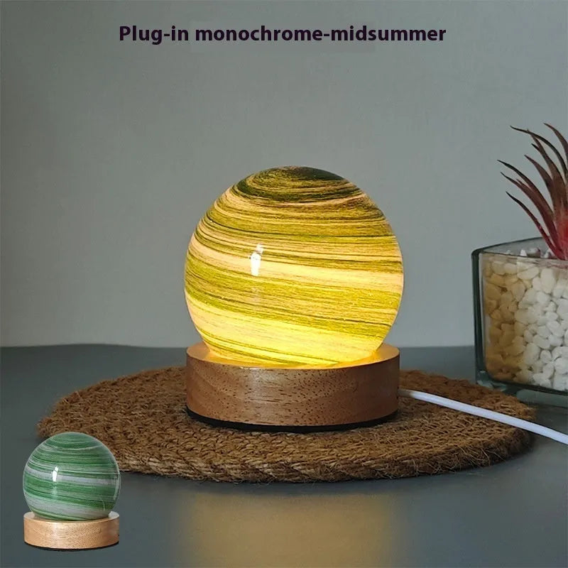 Planet night light with spherical design on base, USB cable connected, showing adjustable three-colour lighting