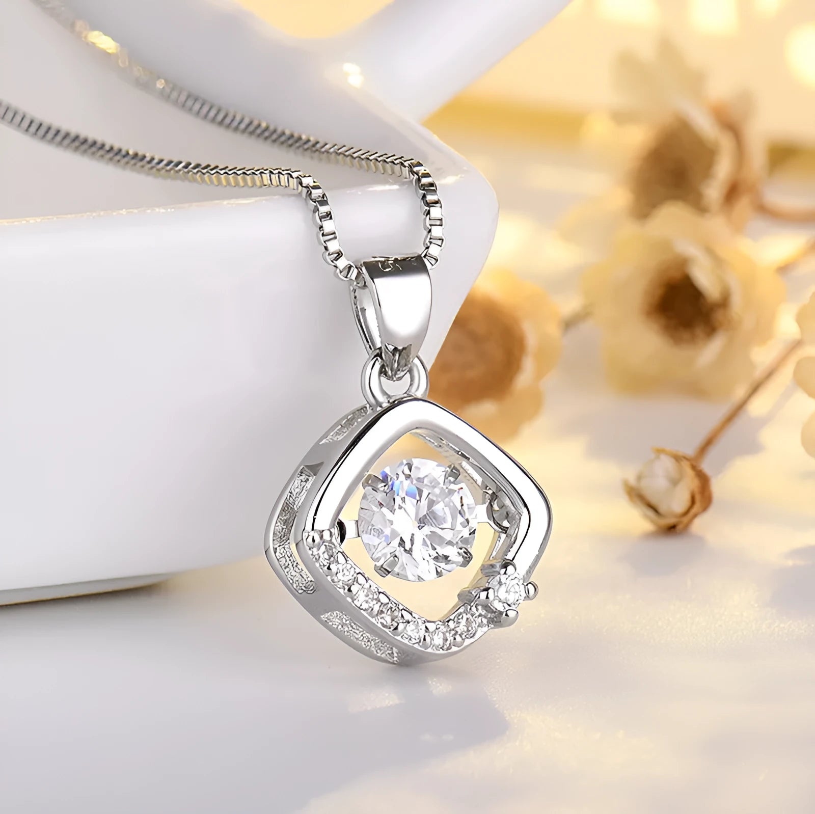 Women's silver heart-shaped pendant necklace with crown and bow decoration on a delicate chain.