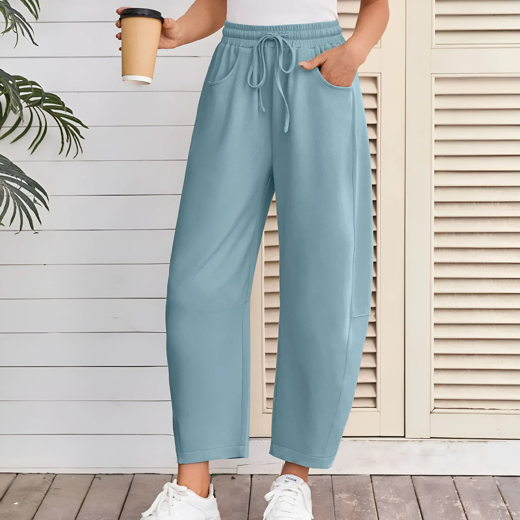 Loose grey cropped sweatpants with elastic drawstring waist and pockets on a mannequin