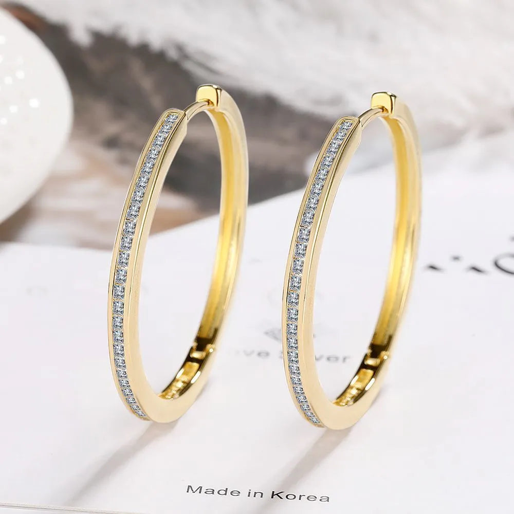Gold-toned copper clip-on earring with round geometric shape and inlaid zircon stone