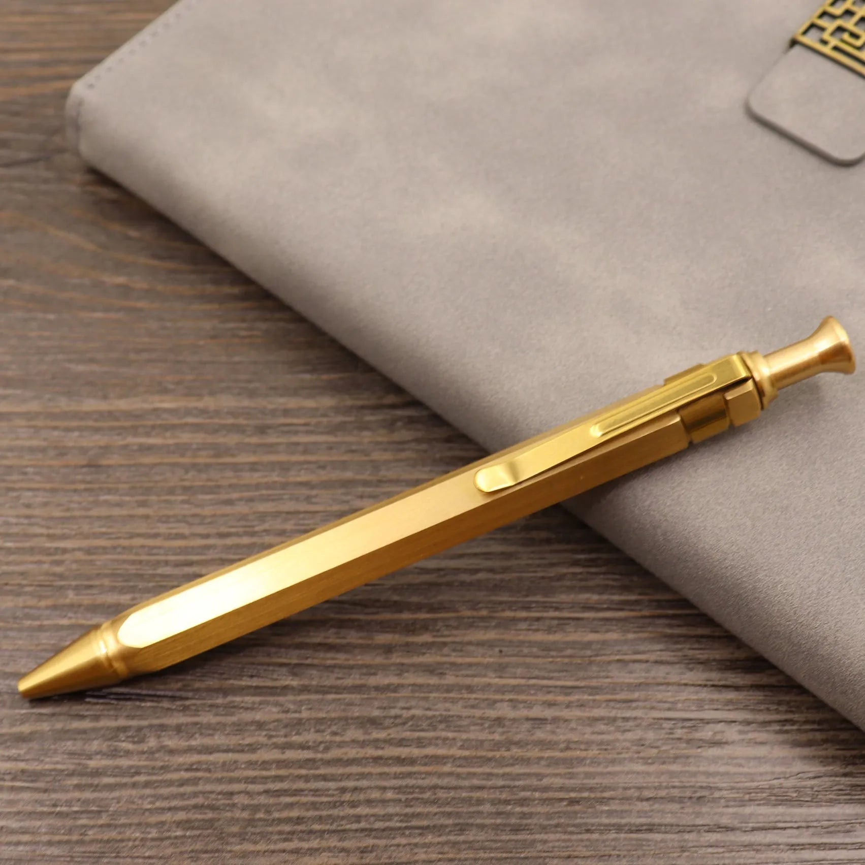 Retro brass tactical pen with cylindrical barrel and six-ring grip, shown with press mechanism extended