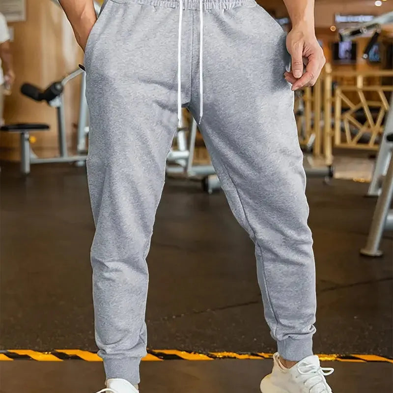 Man wearing grey lightweight linen-style casual trousers with an elastic drawstring waistband.