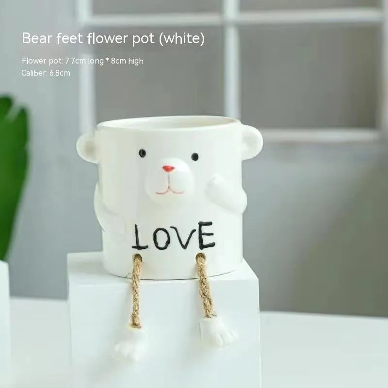 Cartoon style ceramic hanging foot flowerpot for succulent plants on a desktop.