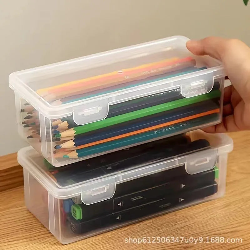 Transparent plastic stationery storage box containing pencils and colour crayons